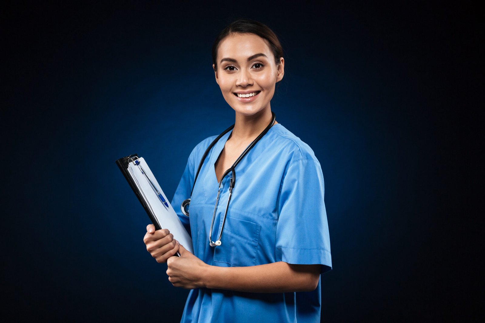 Happy lady doctor in blue uniform and with stethoscope wih folder looking camera isolated